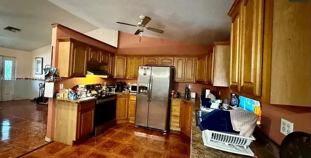 a kitchen with stainless steel appliances granite countertop a refrigerator and a stove