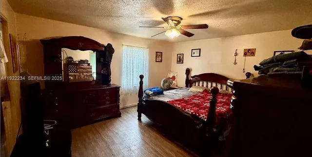 a bedroom with a bed and a mirror on the dresser