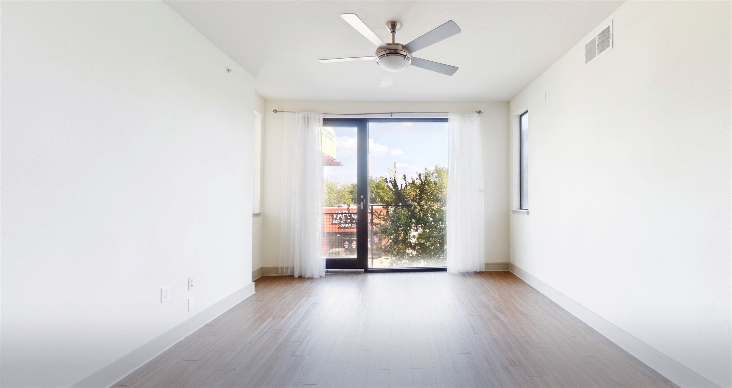 3016 Guadalupe Street, Unit 203 Austin, TX 78705 - Photo 6 of 16 an empty room with wooden floor and windows