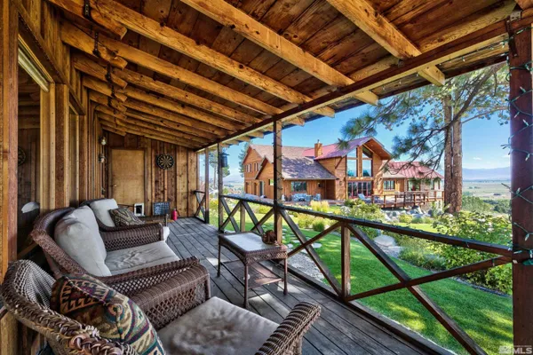 a balcony with wooden floor stairs and furniture