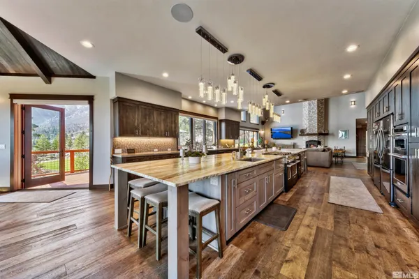 a large kitchen with lots of counter space a sink appliances and a large window