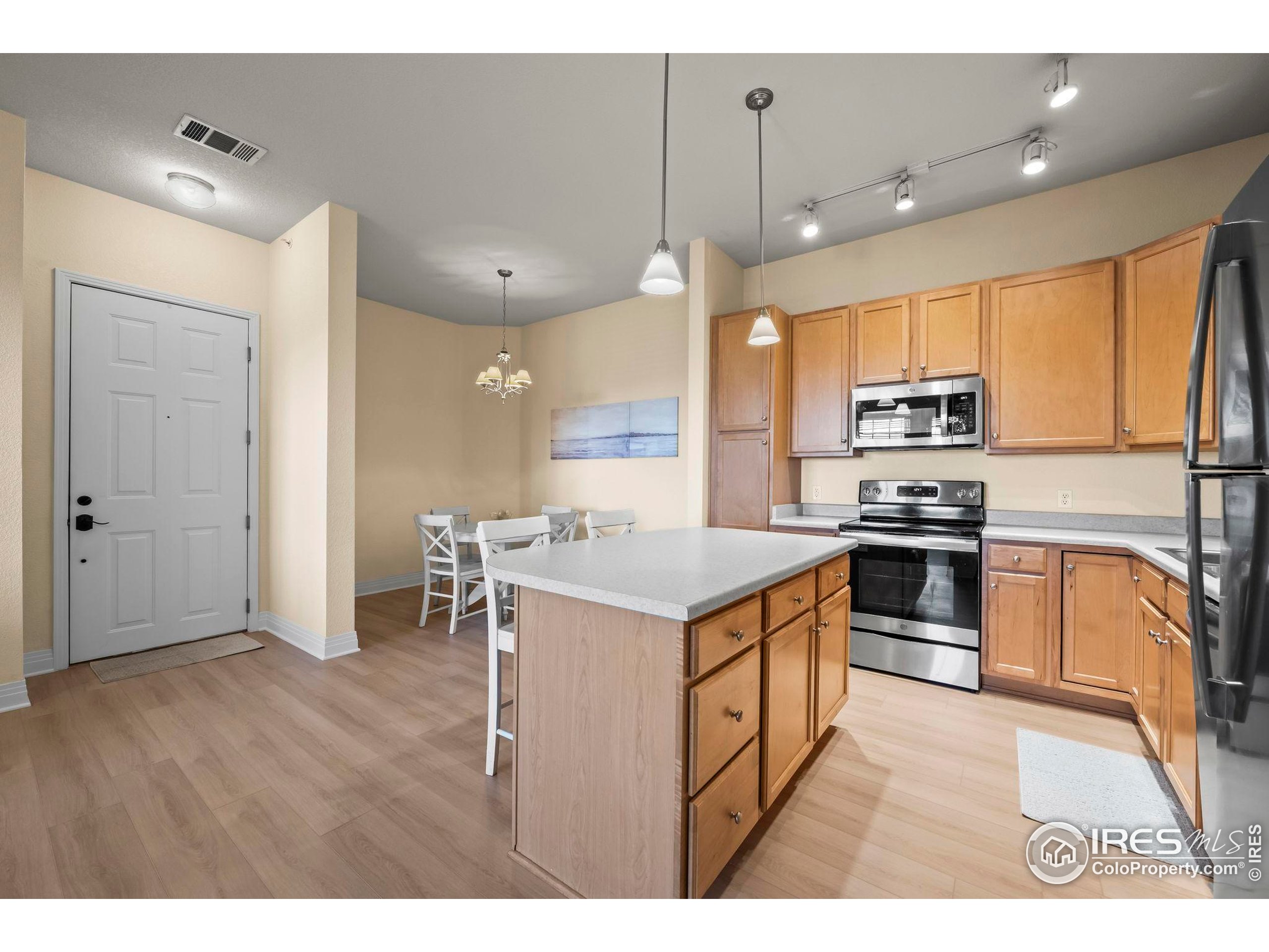 209 Quebec Street, Unit L Denver, CO 80220 - Photo 13 of 46 a kitchen with kitchen island a stove a sink a refrigerator and a microwave