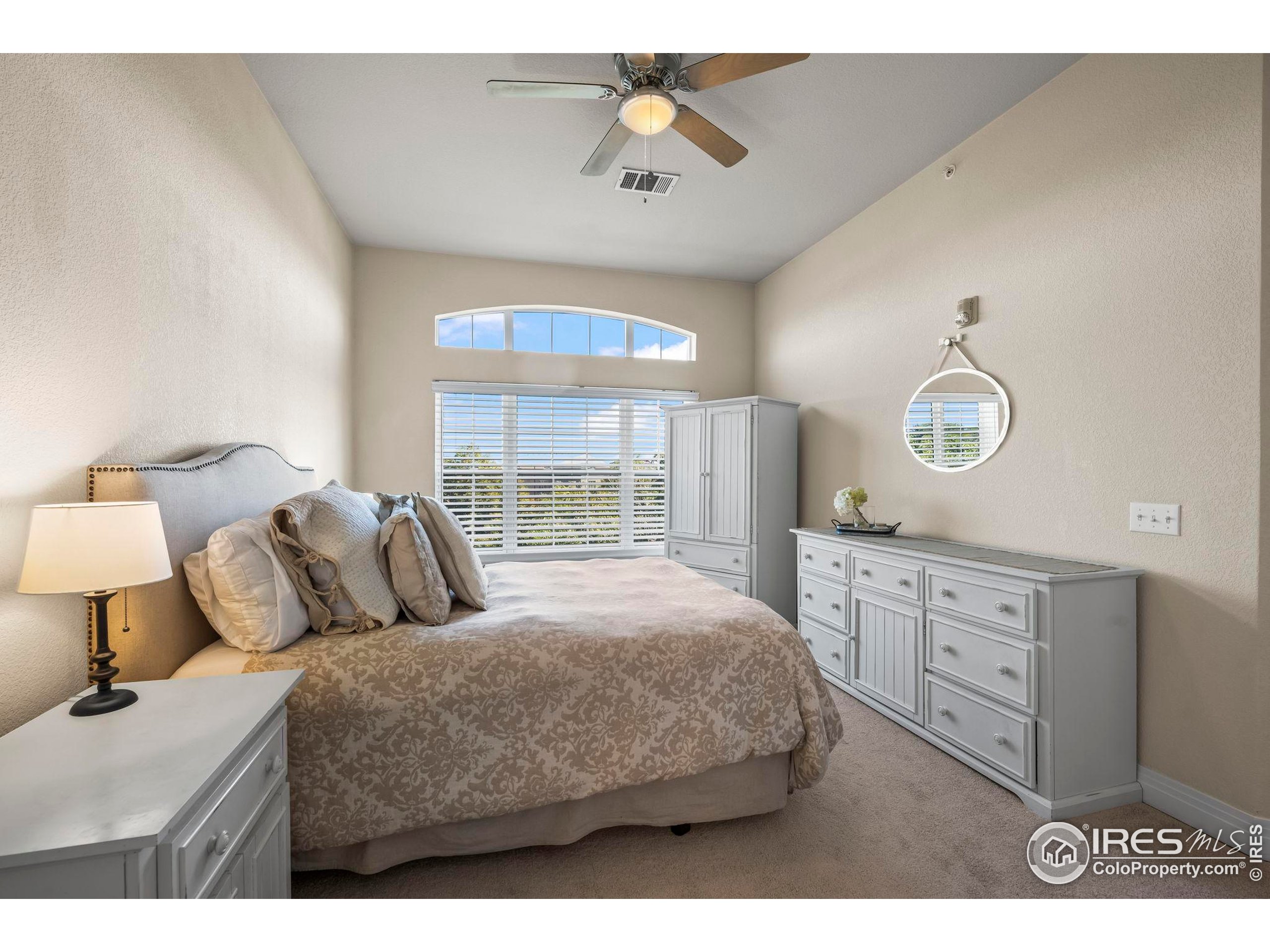 209 Quebec Street, Unit L Denver, CO 80220 - Photo 21 of 46 a bedroom with a large bed and a chandelier