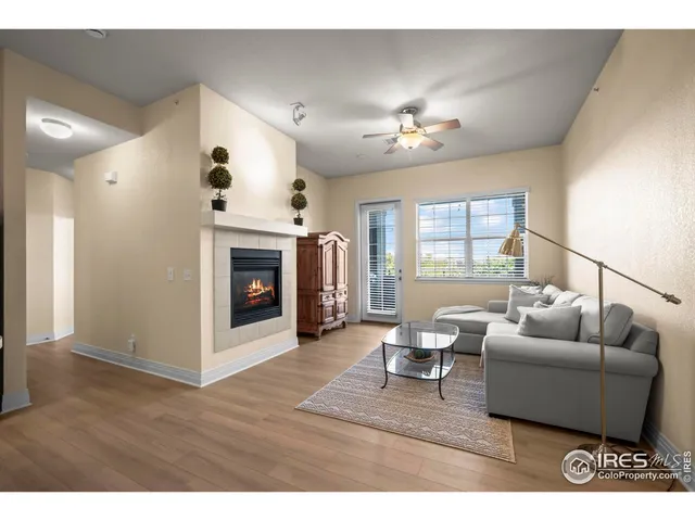 a living room with furniture a fireplace and a ceiling fan