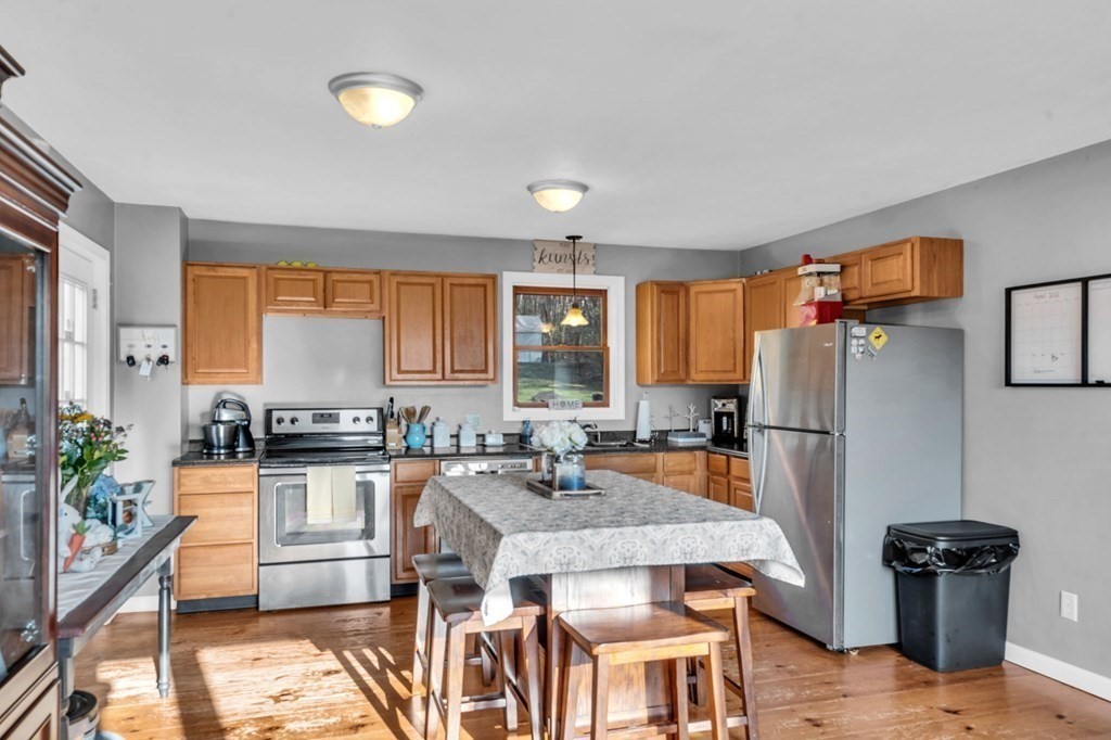570 Cronin Road Warren, MA 01585 - Photo 8 of 25 a kitchen with granite countertop a stove a refrigerator and a dining table