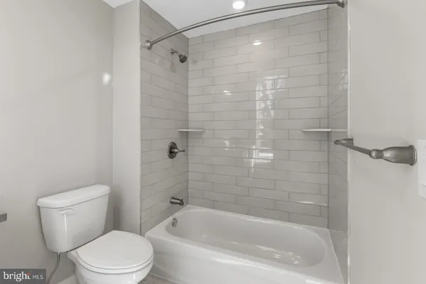 a white toilet sitting next to a bath tub and a shower