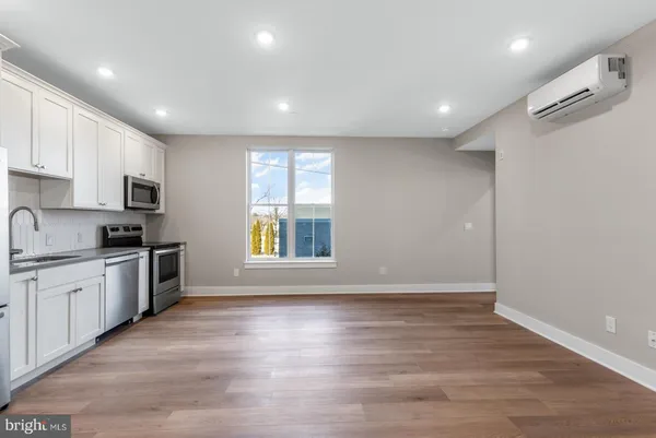 a large kitchen with stainless steel appliances granite countertop a large counter top a sink and a refrigerator