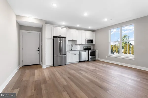 a view of kitchen with wooden floor electronic appliances and window