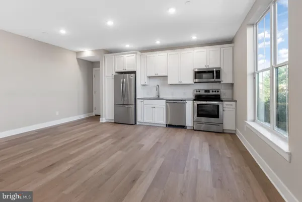 a large kitchen with stainless steel appliances granite countertop a stove a sink and a refrigerator