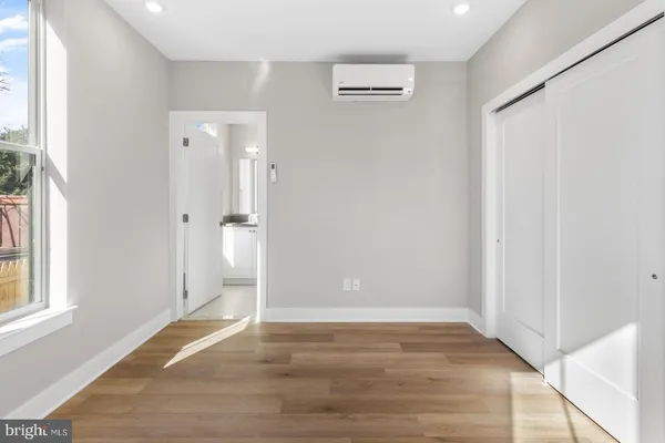 a view of empty room with wooden floor and window