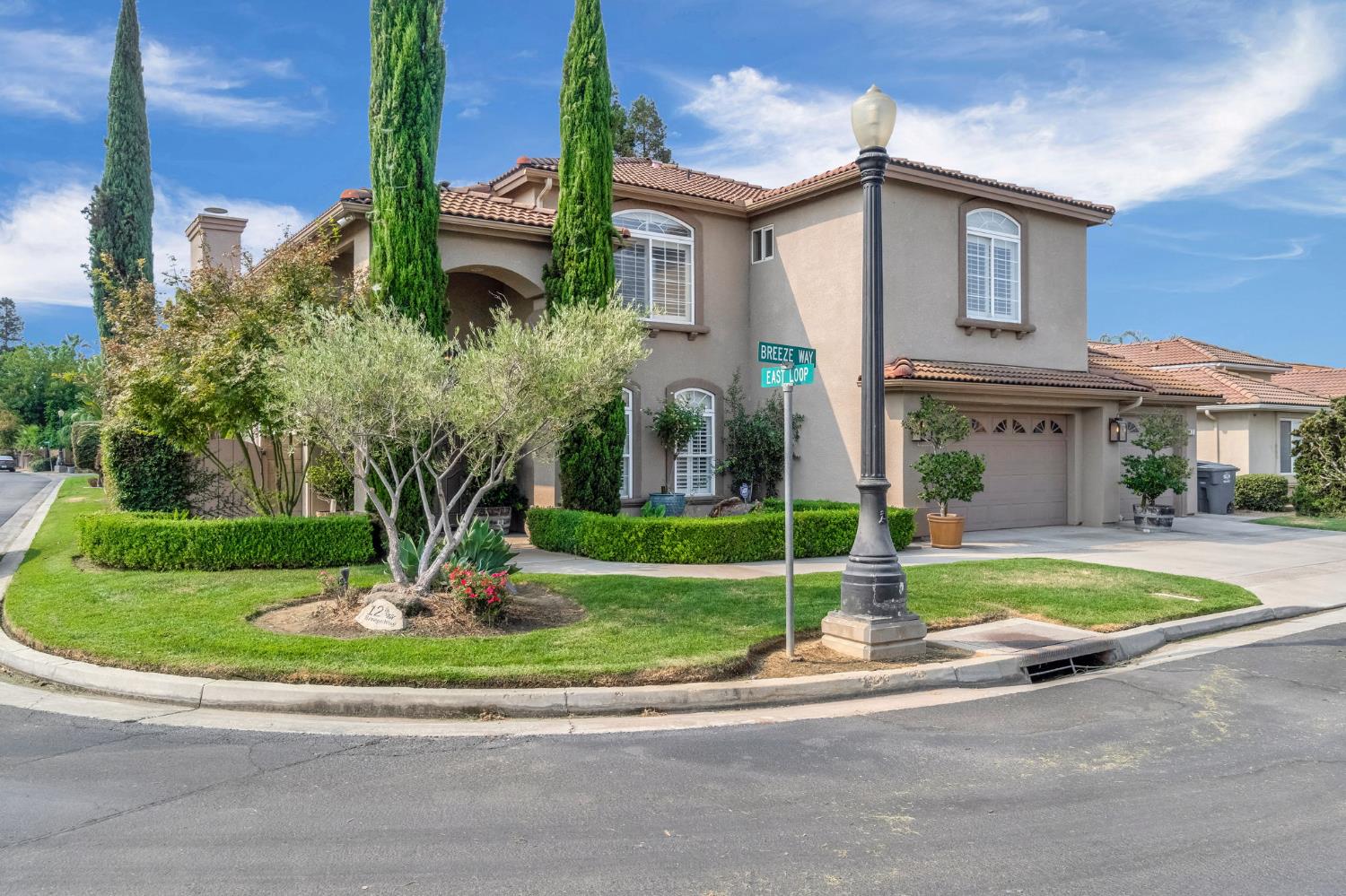 a front view of a house with a yard and potted plants
