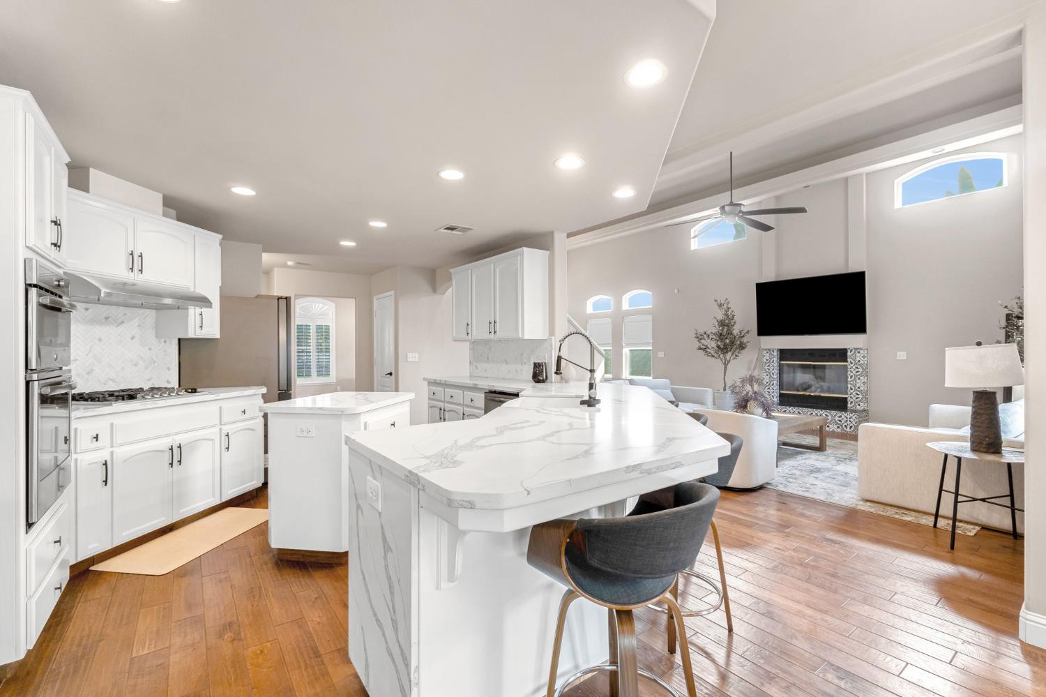 12 Breeze Way Madera, CA 93637 - Photo 12 of 56 a large kitchen with kitchen island a sink a counter space and stainless steel appliances