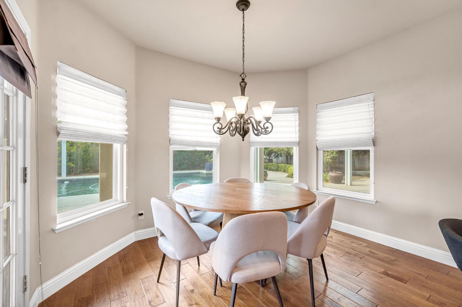 12 Breeze Way Madera, CA 93637 - Photo 13 of 56 a view of a dining room with furniture large windows a chandelier and wooden floor