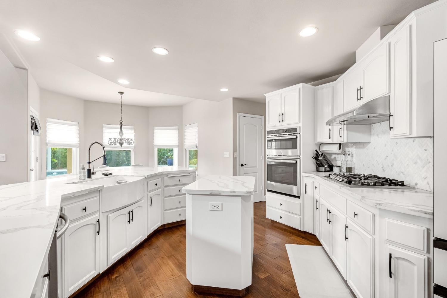 12 Breeze Way Madera, CA 93637 - Photo 16 of 56 a kitchen with stainless steel appliances white cabinets and wooden floors