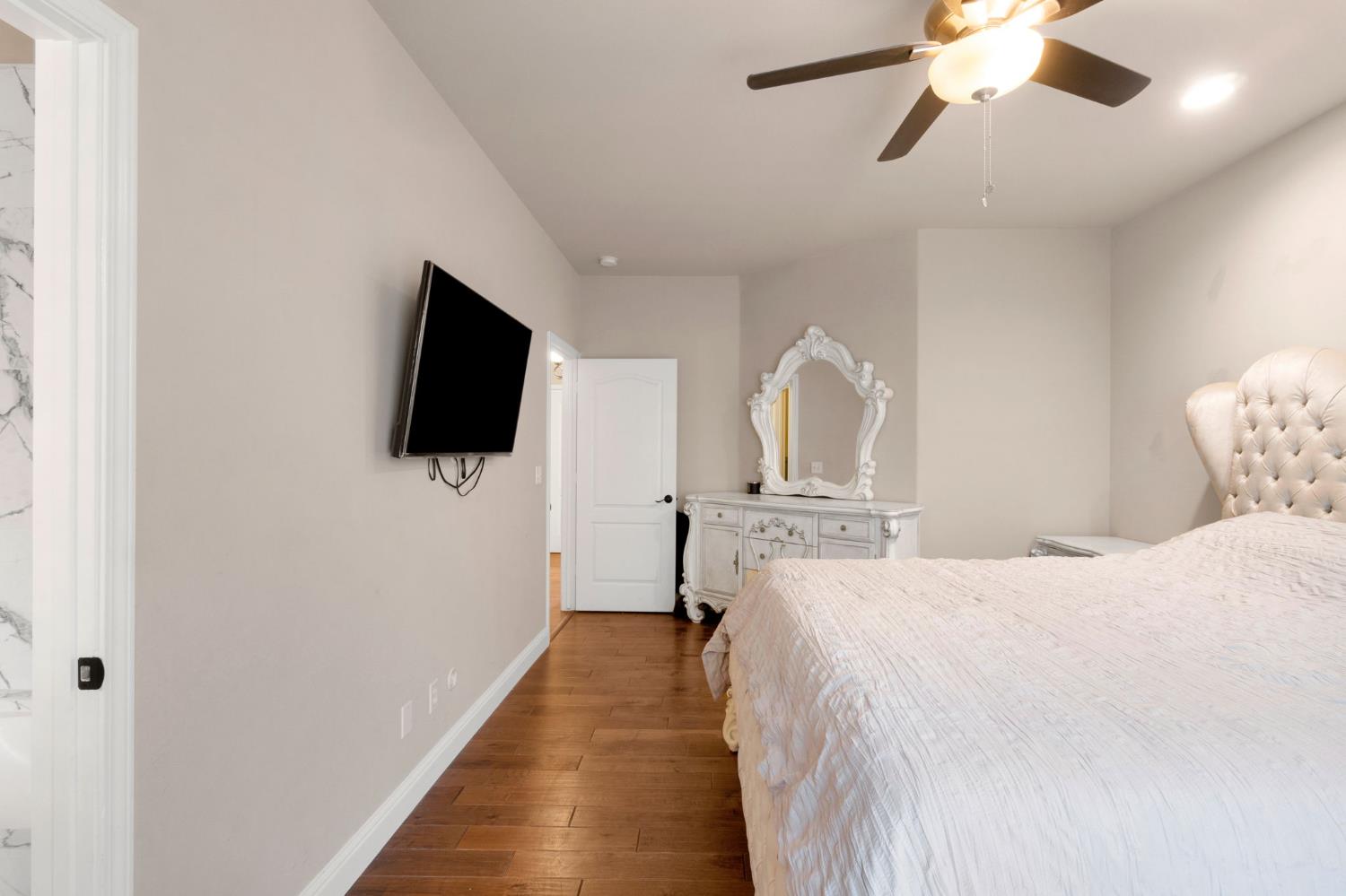 12 Breeze Way Madera, CA 93637 - Photo 23 of 56 a bedroom with a bed and a flat tv screen on wall