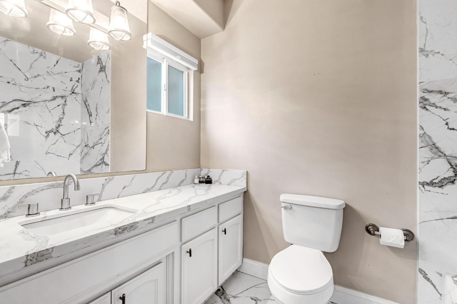 12 Breeze Way Madera, CA 93637 - Photo 24 of 56 a bathroom with a granite countertop toilet sink and mirror