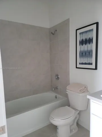 a white toilet sitting next to a bath tub
