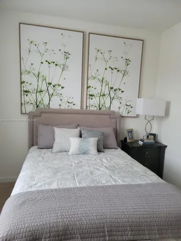 a bedroom with a bed and painting on the wall