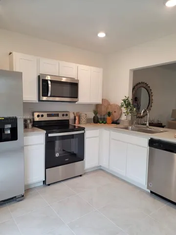 a kitchen with stainless steel appliances a stove microwave and sink