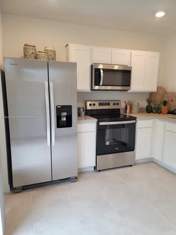 a kitchen with stainless steel appliances granite countertop a refrigerator a stove a sink and dishwasher