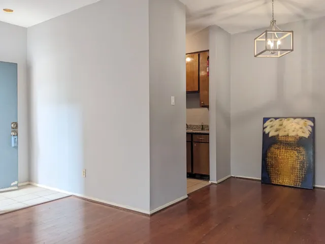 an empty room with wooden floor and hallway