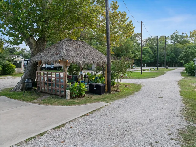 a view of a house with a yard and large tree