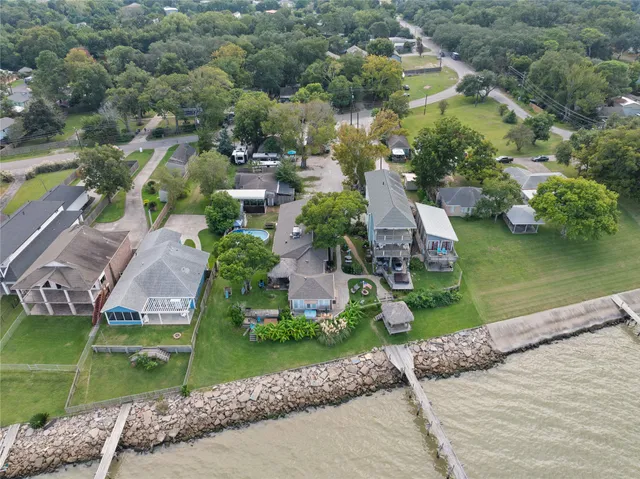 an aerial view of a house with a garden and lake view