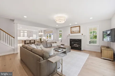 a living room with furniture wooden floor and a large window