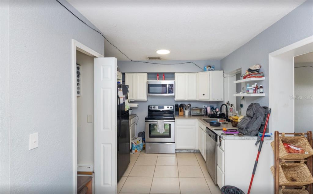 3818 Laso Way Orlando, FL 32822 - Photo 12 of 19 a kitchen with refrigerator and cabinets