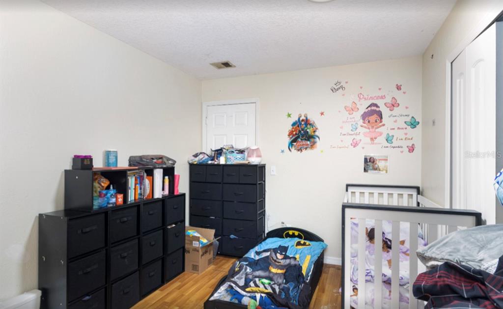 3818 Laso Way Orlando, FL 32822 - Photo 13 of 19 a bedroom with a bed and furniture