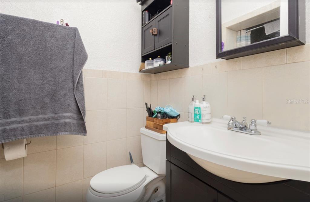 3818 Laso Way Orlando, FL 32822 - Photo 14 of 19 a bathroom with a sink a toilet and mirror