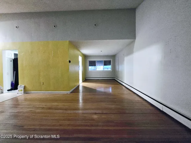 a view of an empty room with a window and fire pit