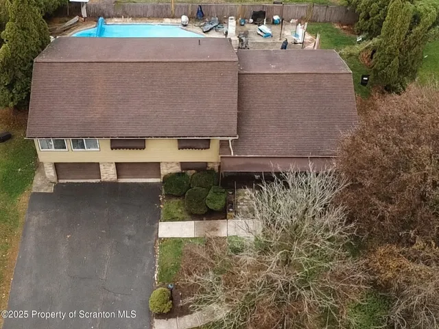 an aerial view of a house with a garden and lake view