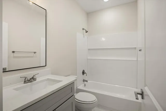 a bathroom with a toilet a sink a mirror a shower and vanity
