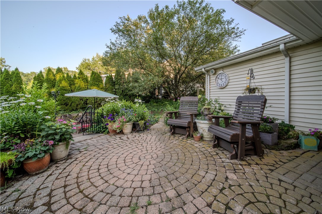 6549 Waterloo Road Atwater, OH 44201 - Photo 42 of 49 Paver patio featuring a circular pattern, mature perimeter landscaping, and a fenced area