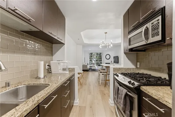 a kitchen with granite countertop a sink stove and cabinets
