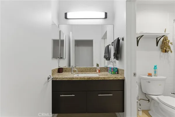 a bathroom with a sink vanity mirror and toilet