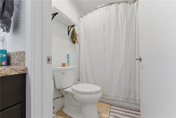 a white toilet sitting next to a shower curtain