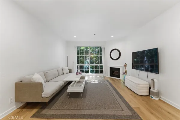 a living room with furniture a window and a flat screen tv