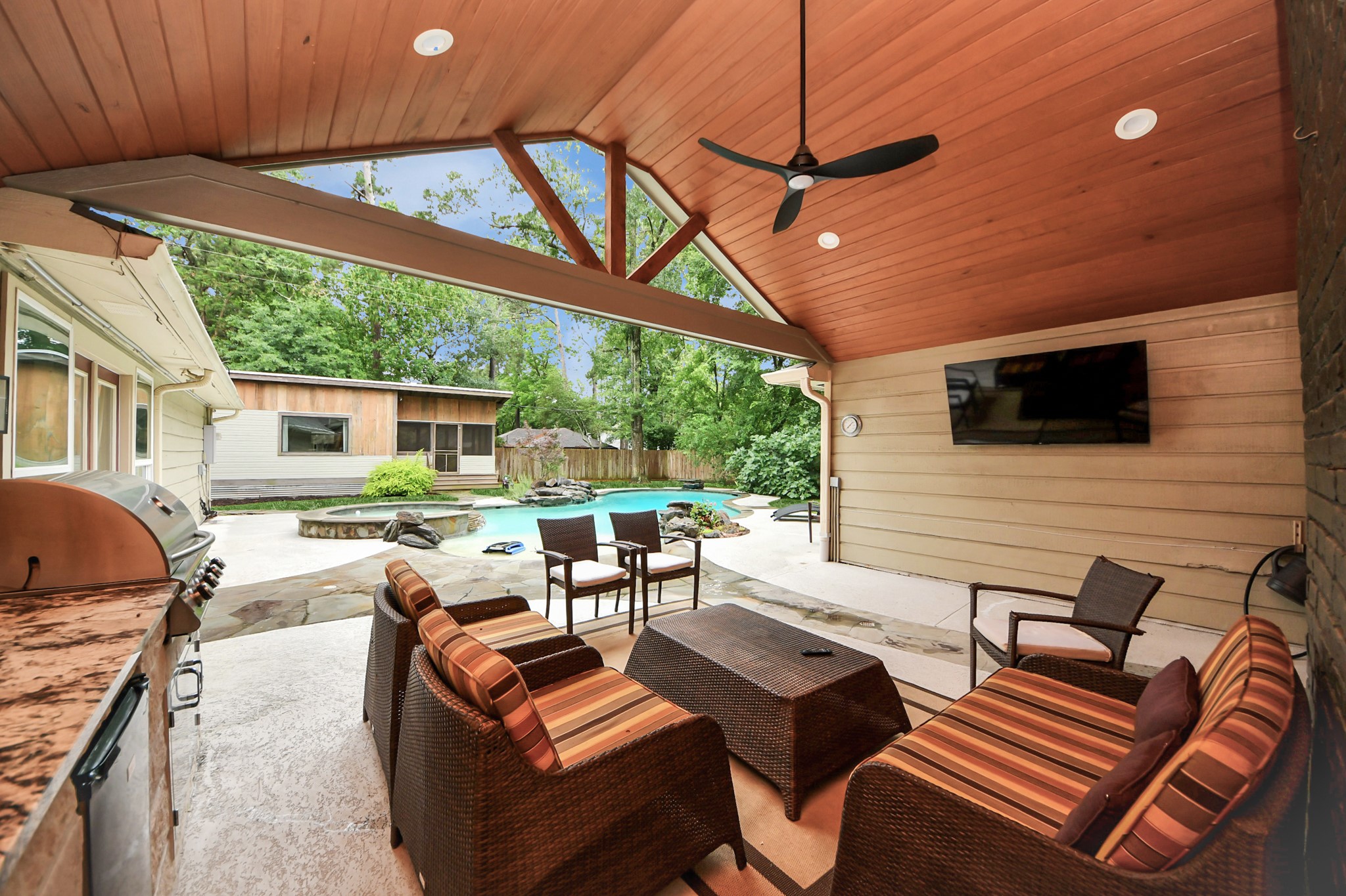 Covered outdoor living area with outdoor kitchen, view of casita and pool