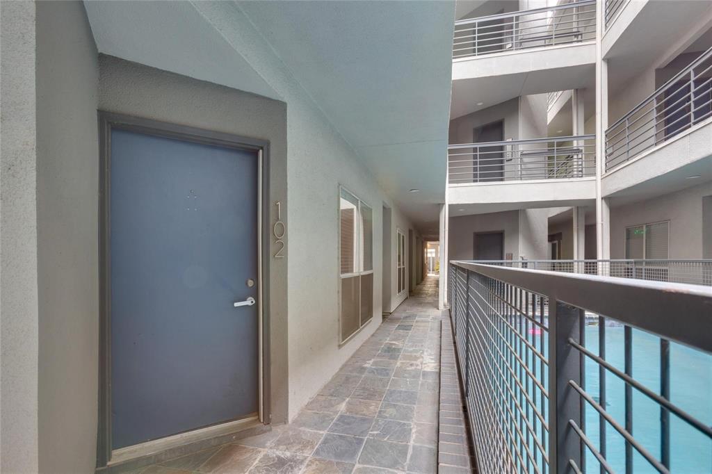 4104 North Hall Street, Unit 102 Dallas, TX 75219 - Photo 6 of 18 Ground-level unit entrance with slate tile flooring, modern exterior door, and contemporary number signage