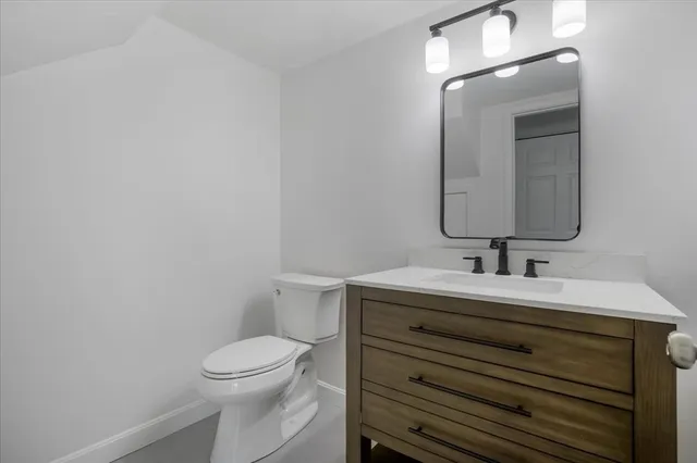 a bathroom with a toilet a sink and mirror