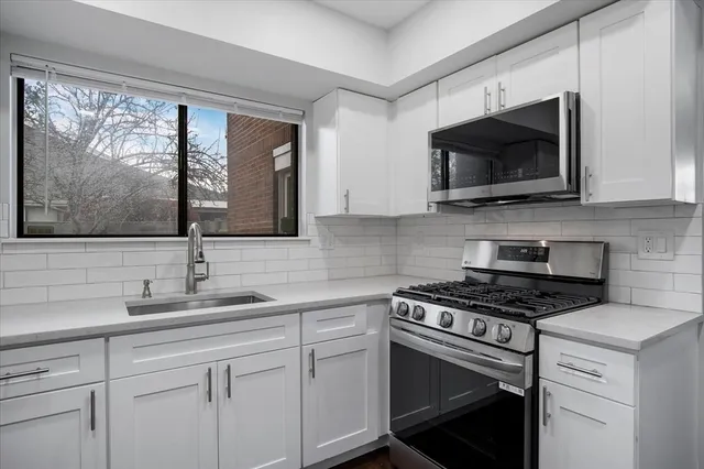 a kitchen with stainless steel appliances a stove microwave and sink