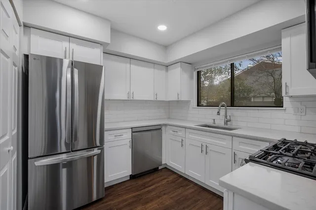 a kitchen with a refrigerator sink and white cabinets