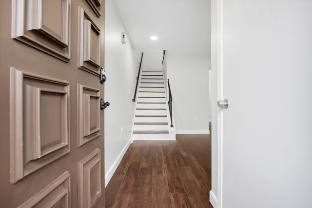 a view of a hallway with wooden floor and staircase
