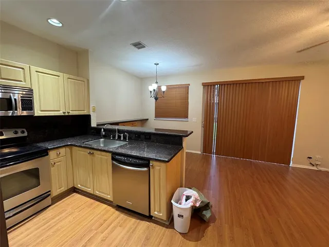 a kitchen with stainless steel appliances granite countertop a sink a refrigerator and a stove