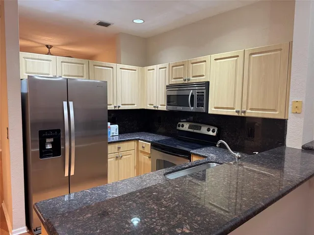 a kitchen with a sink cabinets and wooden floor