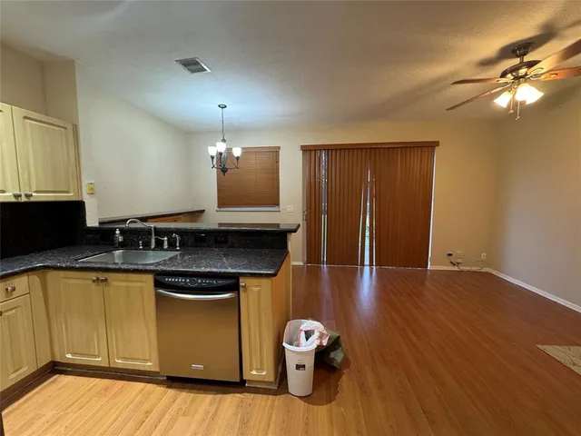 a kitchen with granite countertop white cabinets and black appliances