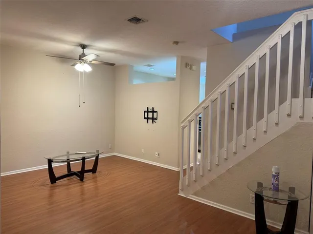 a view of a room with wooden floor and fan