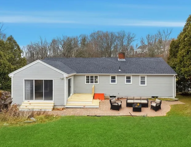a backyard of a house with table and chairs